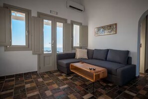 Una sala de estar con un sofá, una mesa de centro y un cuadro en la pared.