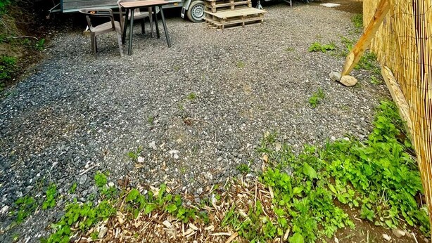 Een stacaravan met een klein terras, een tafel en stoelen.