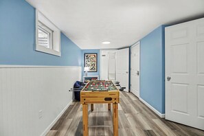 A hallway with a foosball table, a window, and a door. - Comfortable 3 Bedroom Cottage in charming Elk Rapids (Elk Rapids)