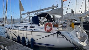 Um veleiro atracado em uma marina, com um endereço de site visível no convés.