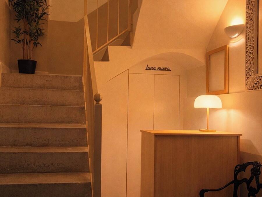 Una escalera con piso a cuadros, un mostrador de recepción de madera y una planta en maceta.