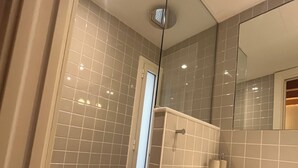 A bathroom with a glass shower enclosure, a white sink with a towel, and a mirror. - HOTEL LUNA NUEVA (Tarragona)