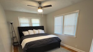 A bedroom with a bed, a ceiling fan, and two windows with blinds. - Masters Week Rental-Spacious cottage in town! (Aiken)
