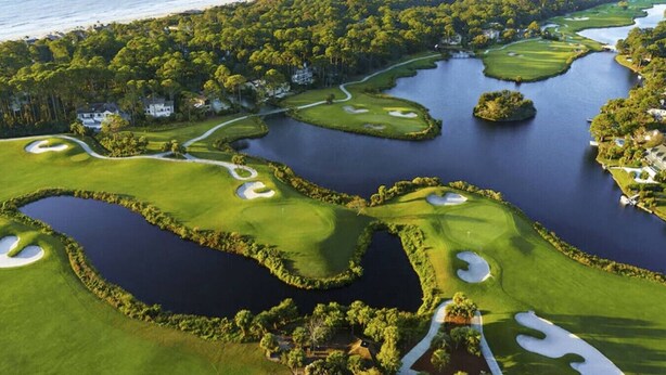 A golf course with multiple water hazards, surrounded by dense forest and a beach. - Palmetto Dunes Villa – Golf, Pools & Bike to Beach (Hilton Head Island)