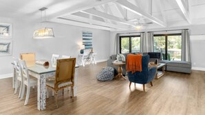 A spacious living area with a dining table, chairs, a sofa, and a television. - Palmetto Dunes Villa – Golf, Pools & Bike to Beach (Hilton Head Island)
