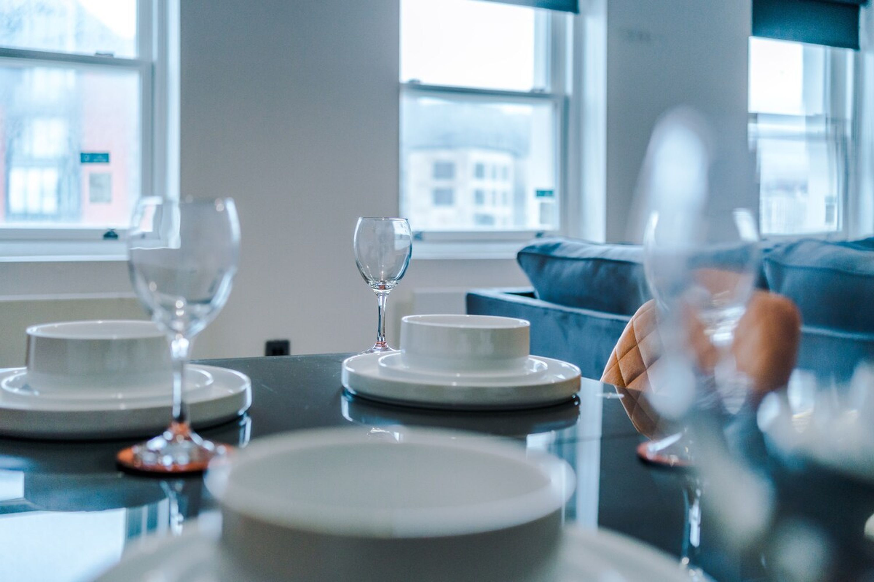 Une table à manger avec des assiettes, des verres et une tasse, le tout préparé pour un repas.