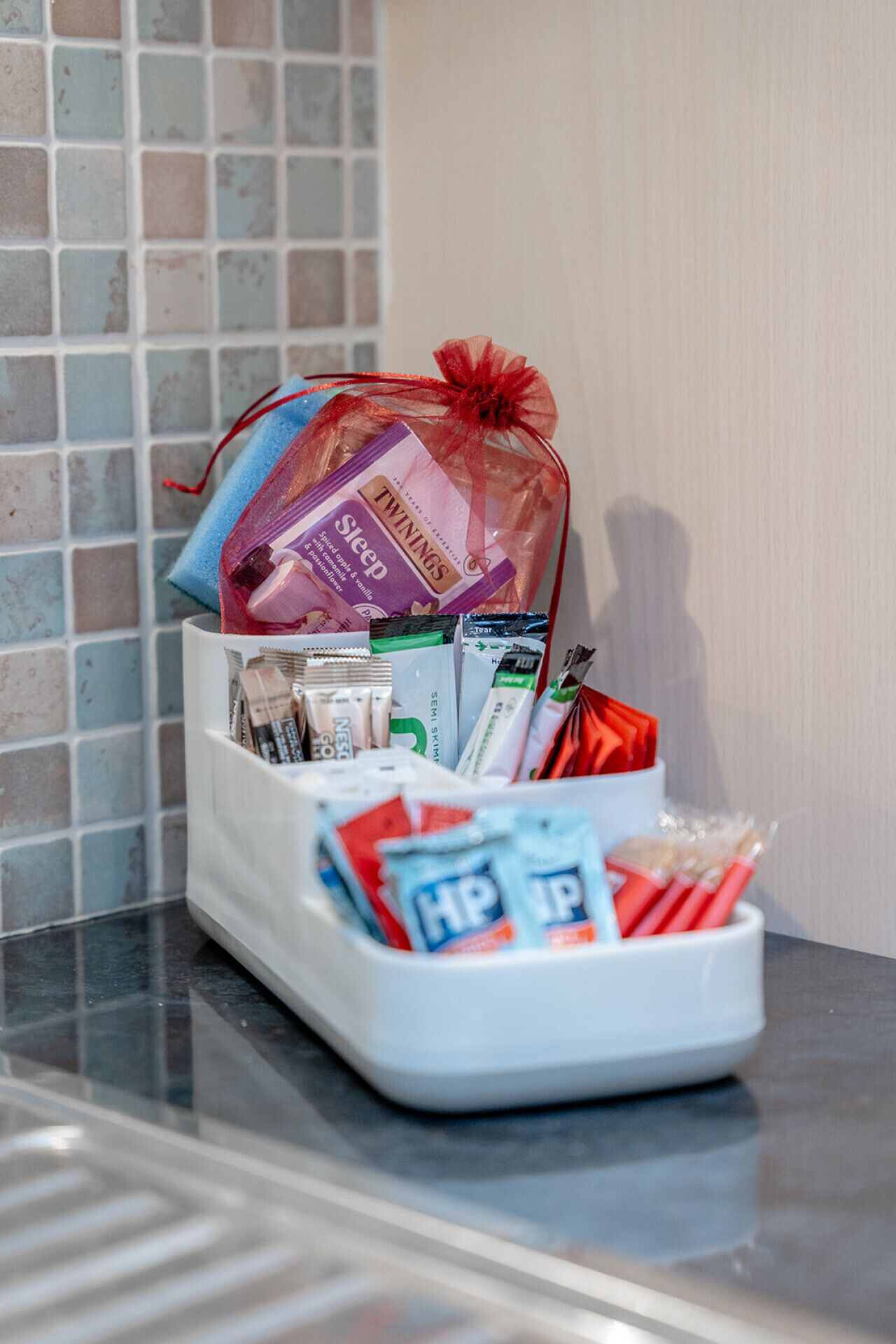 A tray with toiletries and a gift bag on a counter.