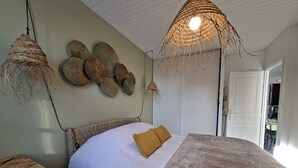 Een slaapkamer met een bed, een tafel en een bankje.