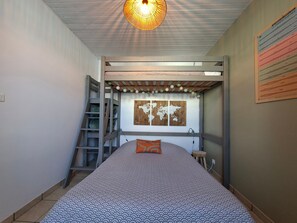 A bunk bed with a ladder, a world map on the wall, and a hanging light fixture.