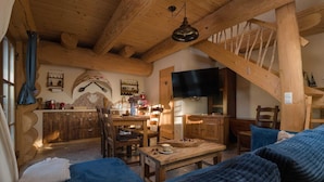Un interior rústico de madera con comedor, cocina y zona de estar.