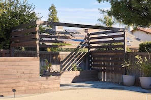 A wooden pergola structure with solar panels in the background. - Retro Ranch | Home Theater, Pool/Spa, Pet Friendly (Fresno)