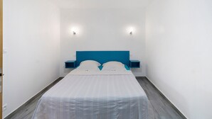 Ein Schlafzimmer mit einem Bett, zwei Nachttischen und Wandleuchten.