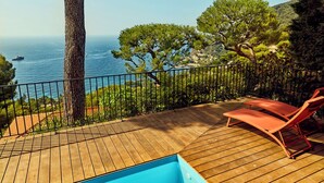 A wooden deck with a pool, lounge chairs, and a view of the sea. - Wonderfull view! (Èze)