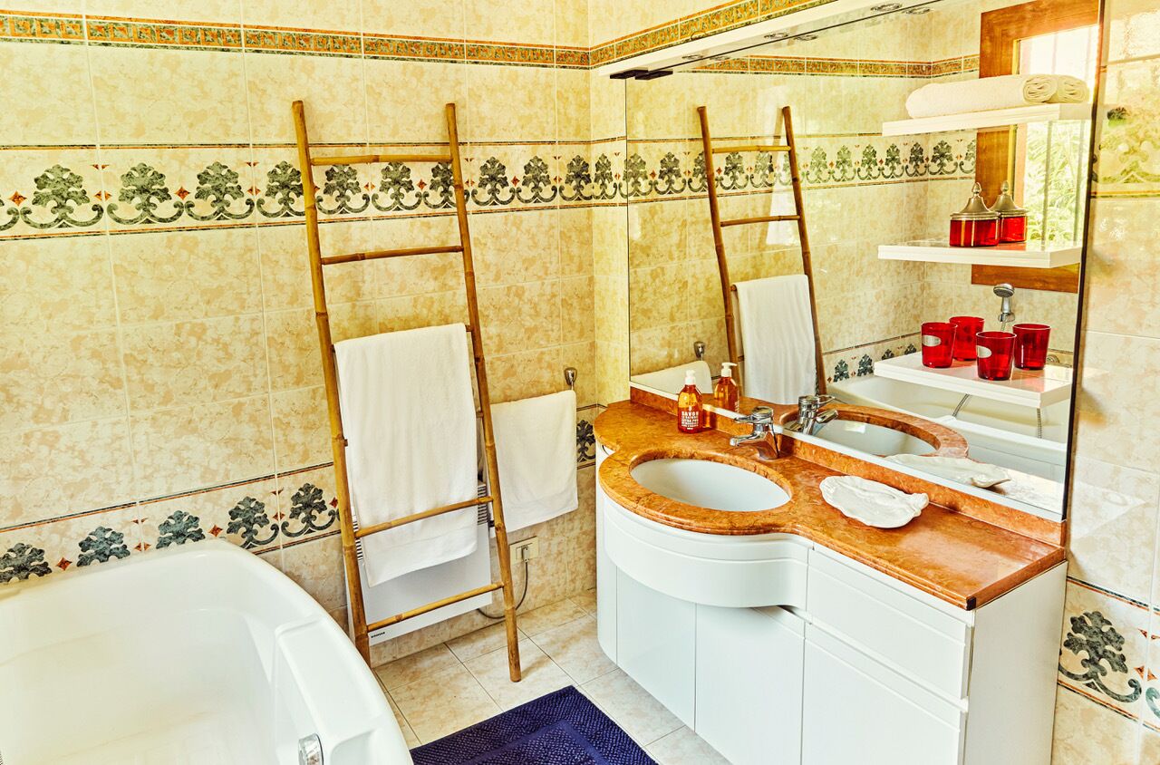A bathroom with two sinks, a bathtub, a mirror, and a towel rack.
