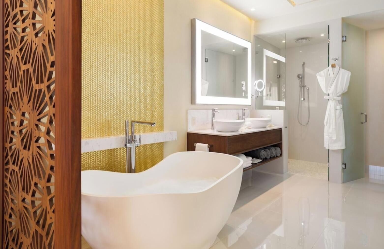 Ein modernes Badezimmer mit freistehender Badewanne, zwei Waschbecken und einer bodengleichen Dusche.