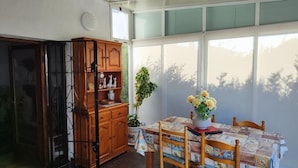 Un coin repas avec une table dressée pour quatre personnes, un meuble en bois et une plante en pot.