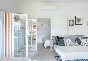 Un dormitorio moderno con cama, armario y zona de escritorio.