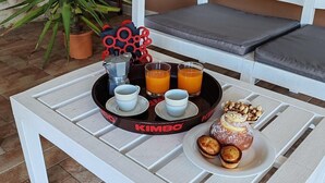 A white outdoor seating area with a tray of food and drinks, including a pastry, coffee cups, and orange juice. - Ruralholidays Experience in the Heart of Salento (Castri di Lecce)