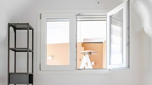 A bedroom with a white bed, a white dresser, a black shelving unit, and a window with an open blind. - Ruralholidays Experience in the Heart of Salento (Castri di Lecce)