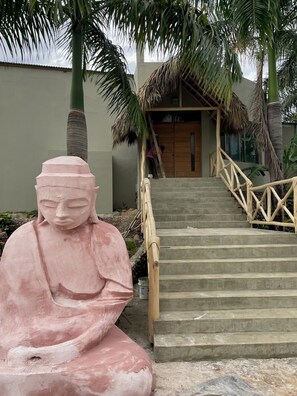 A statue of a seated figure, a staircase with wooden railings, and a building with a thatched roof. - 6 BR, 5 Bath Private Ocean & Jungle View Villa w/Pools (Las Terrenas)