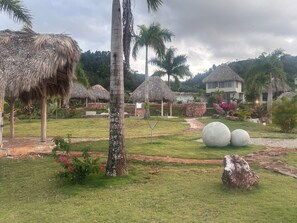 A tropical resort with thatched-roof structures, palm trees, and a well-maintained garden. - 6 BR, 5 Bath Private Ocean & Jungle View Villa w/Pools (Las Terrenas)