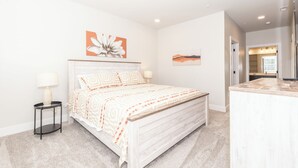 Ein Schlafzimmer mit einem Bett, Nachttischen und Kunstwerken an den Wänden.