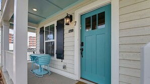 Una casa con una porta color petrolio, una cassetta delle lettere e il numero 1209 sulla parete.