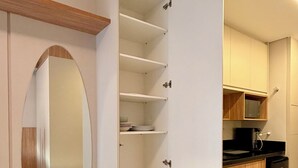 Eine moderne Küche mit weißen Schränken, einem schwarzen Kühlschrank und einer Mikrowelle.