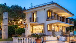 A two-story house with a balcony, a stone pillar, and a potted plant. - Villa Nerissa - Letojanni (Letojanni)