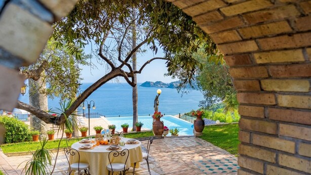A patio with a table set for dining, overlooking a pool and the sea. - Villa Nerissa - Letojanni (Letojanni)