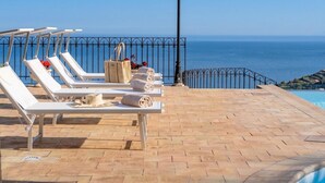 A poolside area with sun loungers, towels, and a lamp post. - Villa Nerissa - Letojanni (Letojanni)