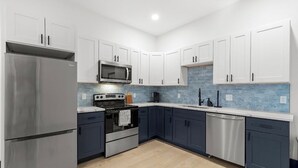 A modern kitchen with white cabinets, a stainless steel refrigerator, a microwave, an oven, and a dishwasher. - Welcome to Blue Haven Retreat, beautifull 2- bedroom located in South St. Louis (St. Louis)