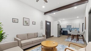 A modern living room with a sofa, a coffee table, and a dining area with chairs. - Welcome to Blue Haven Retreat, beautifull 2- bedroom located in South St. Louis (St. Louis)