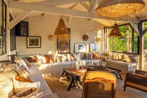 A sunlit room with a white sofa, wicker furniture, and woven ceiling lamps. - DOMAINE6ha - EXCEPTIONAL VIEW OVER BEYNAC CASTELNAUD AND MARQUEYSSAC SWIMMING POOL 5X15 (Vézac)