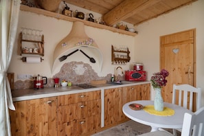 A rustic kitchen with wooden cabinets, a stone backsplash, and a heart-shaped door. - Comfortable Apartment, 2 Levels, Close to Beach (gmina Będzino)