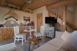 A cozy interior with a wooden staircase, a dining area with a round table, and a sofa. - Comfortable Apartment, 2 Levels, Close to Beach (gmina Będzino)