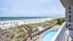 A beach view from a balcony with a swimming pool, beach umbrellas, and a sandy beach. - Island Princess 406 (Fort Walton Beach)