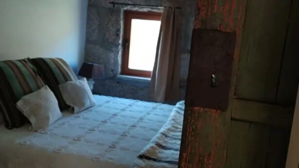 Un dormitorio con cama, almohadas, ventana y puerta.