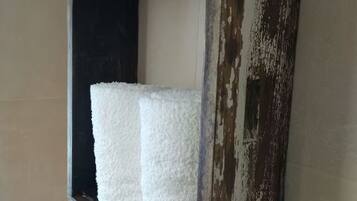 A window with a white textured object, possibly a towel or decorative item, and a weathered wooden frame.