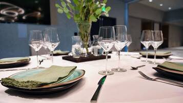 Une table mise pour le repas, avec des assiettes, des verres et des couverts.