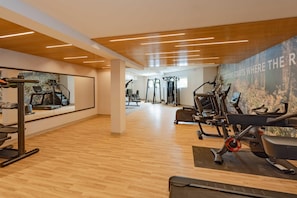 A gym with cardio machines, weightlifting equipment, and a mirror wall. - The Mindaro, part of JdV by Hyatt (Portland)