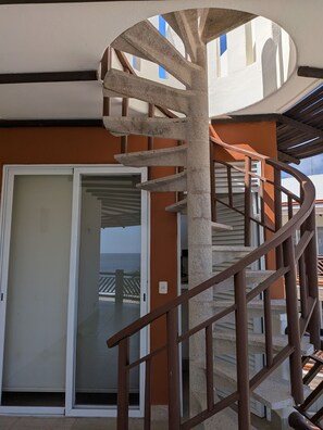 A spiral staircase with a metal railing, leading to a balcony with a view of the sea. - 3 Bdm 2 Storey Penthouse Palapa Ocean View (Bajos de Chila)