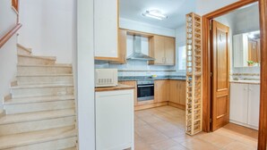 Une cuisine avec des meubles de rangement en bois, un four à micro-ondes et une cuisinière.