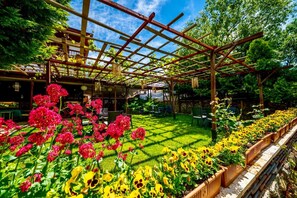 A garden with a pergola, outdoor seating, and flower beds. - Birol Sengun Bag Evi  (Safranbolu)