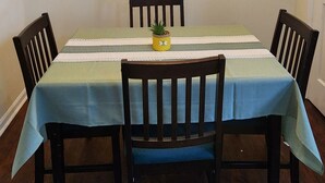 A dining area with a table, chairs, a ceiling light fixture, and a potted plant. - Near Sherman College 2BR w/ Wi-Fi + Washer/Dryer (Boiling Springs)