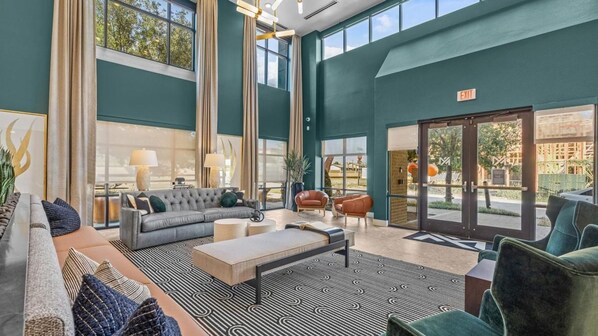 A spacious lobby with a grey sofa, a coffee table, and a patterned rug.