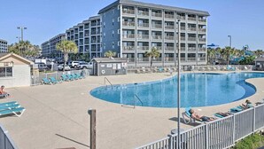 A hotel with a swimming pool, multiple balconies, and a parking area. - Ocean View-Family Friendly condo, 211B, in Myrtle Beach Resort (Myrtle Beach)