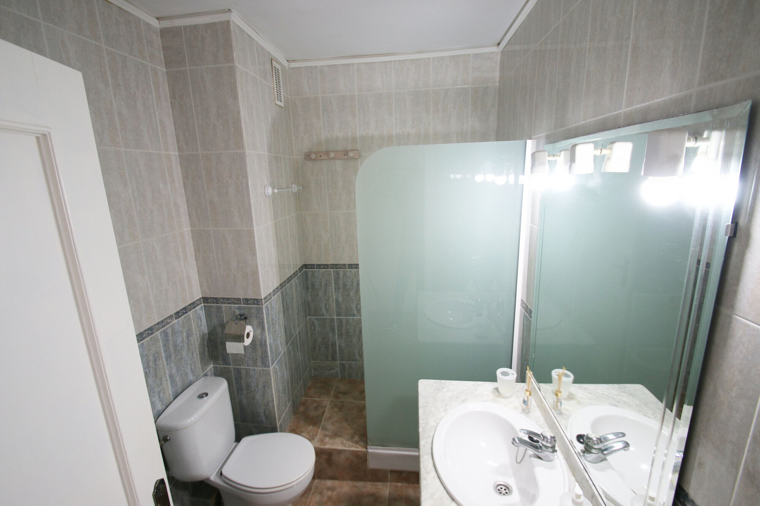 Ein Badezimmer mit Toilette, Waschbecken und Dusche.