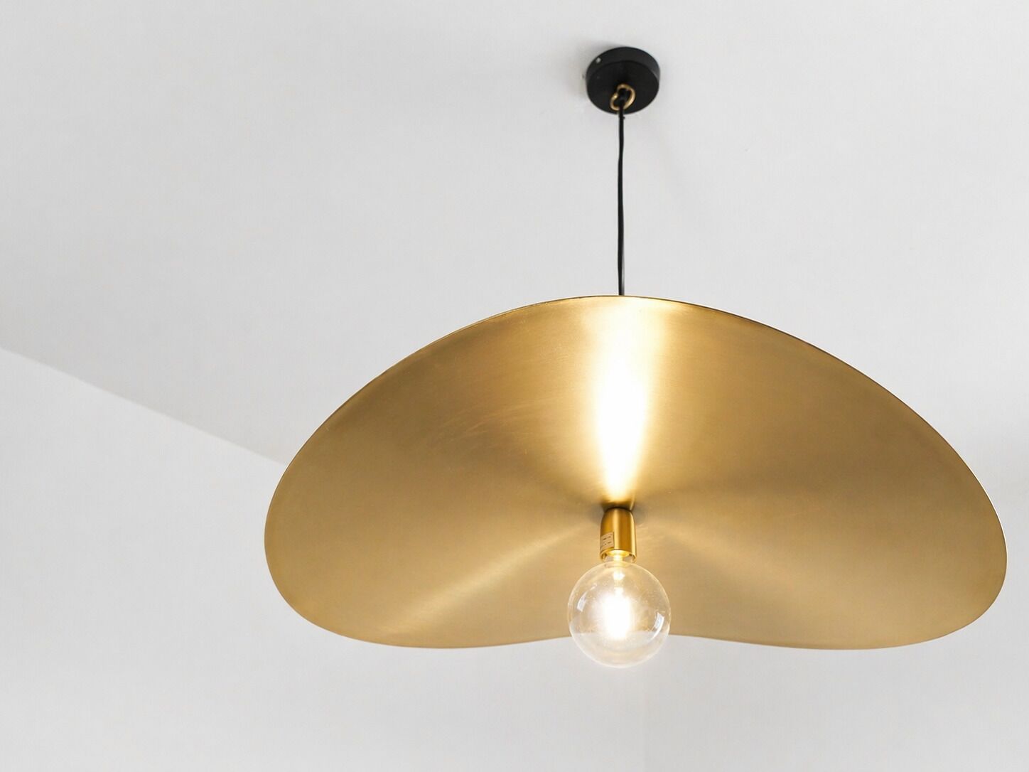Un luminaire suspendu doté d’une ampoule sphérique.