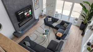 Een moderne woonkamer met een flatscreen televisie, twee banken, een salontafel en een groot raam met uitzicht.
